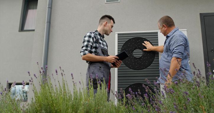 2 men doing maintenance on an HVAC which when done along with a Scrubber Ducts HVAC vent cleaning helps your AC run better.